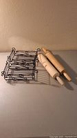 Two wooden rolling pins, one marked "Foley," and two black wire napkin holders with curled wire designs shown from above.