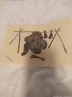 Photo showing full artwork depicting Inuit figure with fish drying racks, signed 'Nanogak'