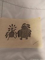 Full view of the stonecut print featuring two birds on paper, showing the signature and general condition.