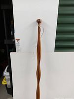 Amish twist wood walking stick standing upright against a white backdrop showing overall view with handle and rubber tip visible.