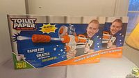 Front view of two boxed Toilet Paper Blasters showing packaging and branding