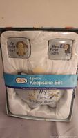 Front view of the 4 piece baby keepsake set in damaged packaging.