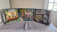 Photo showing three boxed escape room games including Jumanji Escape Room The Game, Operation Escape, and Escape Room The Game with three scenarios.