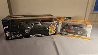 Photo of two boxed model cars: remote control Dom's Ice Charger from Fast and Furious and a diecast 1957 Chevy Corvette