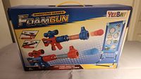 Front of boxed YeeBay Foam Gun Shooting Games set showing included foam guns, darts, and target board with stand.
