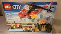 Front photo of LEGO City Fire Helicopter Set 60108 box showing the assembled helicopter, motorcycle, fire station, and minifigures with recommended age 5-12 and piece count 257.