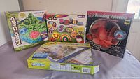 Photo showing all four main items: kinetic sand castle set, rock art kit, volcano science kit, and light up tracing pad.