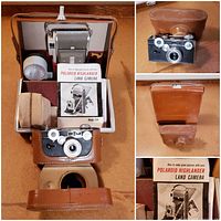 Polaroid Highlander Land Camera with attached flash bulb, leather carrying case, light reducing filter in case, film canister, and instruction manual displayed inside the open case.