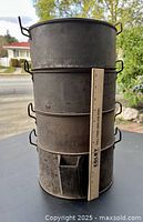 Stacked four-tier copper bottom steamer showing height compared to a measuring stick about 12 inches tall.