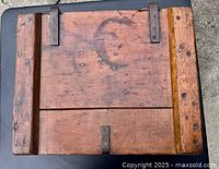 Top view of the antique wooden box showing metal hinges and wood planks with nail marks.