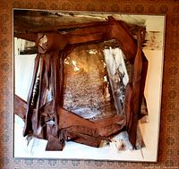 Front view of framed artwork showing layered wood elements over oil-painted canvas