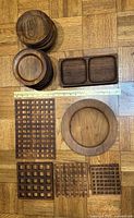 Full view of all items laid out showing four square lattice trivets, one round medium plate, small plates stacked, and the rectangular serving tray.