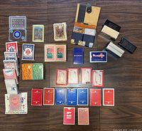 Top view of all playing card decks arranged on floor showing variety of brands and packaging.