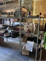 Photo of the metal wire shelving unit with various miscellaneous items stored on it (items not included). Shows the shelving unit's structure, 4 full-size shelves, and a smaller shelf not attached.