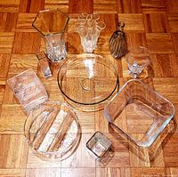 Photo showing all 10 glass pieces arranged on wood floor including various shaped vases and bowls