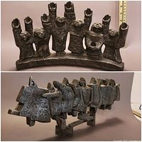 Seven-figure cast metal menorah on arched base with ruler at rear showing approximately 7-inch height