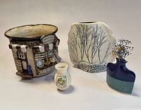 Four ceramic pieces together showing the crock pot and three small vases, displaying sizes and styles.