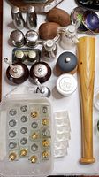 Top view of various salt and pepper shakers and grinders including wood, metal and ceramic types with one wooden baseball bat beside them.