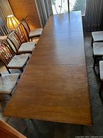 Table fully extended with three leaves installed, chairs not included.