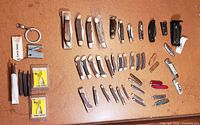 Overhead view of all folding knives, multi-tools, sharpeners and keychain tools spread on tabletop