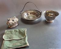 Four pieces including covered ashtray, a handled basket/server, a bowl, and a cloth pouch