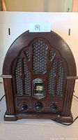 Front view of the GE vintage style wooden antique radio showing the front grille, mesh, tuning dial, and knobs.