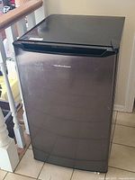 Closed black mini fridge with Hamilton Beach logo on front, showing overall condition and size.