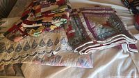 Three folded quilts displayed on bed: patchwork, log cabin style, floral scalloped.