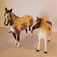Front view of both porcelain horse figurines side by side