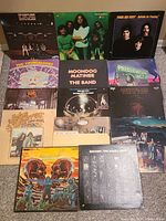 Overall grid of 12 album covers laid out on carpet.