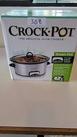 Front of Crock-Pot box showing product name and image of slow cooker with food inside.