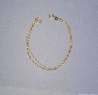 Three-strand gold bracelet laid flat to show entire piece