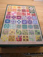 Closed puzzle box featuring colorful patchwork quilt block pattern image and branding details.