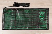 Top view of PlantBest seedling heating mat showing detailed text, safety certifications, and power cord.