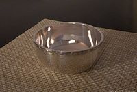 Front and top view of the silver bowl showing smooth shiny interior and rounded shape