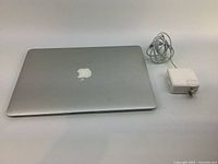 Closed silver MacBook Air with charger beside it