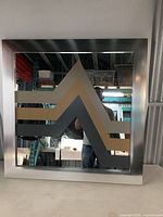 Front view of the square Mid-Century Modern mirror with metal frame and geometric zig-zag pattern.