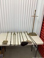 Full set displayed on white table in front of storage unit door, showing all tools and stand.
