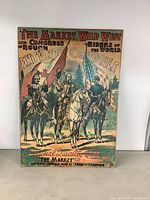 Frontal view of vintage reproduction Western marketing poster on board, displaying three horseback riders and flags with promotional text.