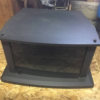 Black TV stand photographed from above front angle showing glass door and top surface