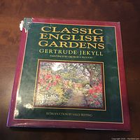 Front cover of the book Classic English Gardens by Gertrude Jekyll showing title, artist of paintings George S. Elgood, and introduction by Sally Festing. Dust jacket has minor damage.