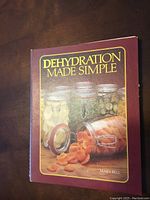 Front cover of 'Dehydration Made Simple' showing jars of dried produce including apricots and other dried fruits or vegetables.