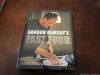 Front cover of cookbook featuring Gordon Ramsay preparing food.