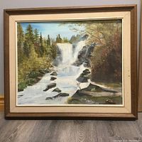 Framed painting of a waterfall scene with trees and rocks, signed by Joan Hopkins and dated 1988.