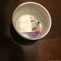 Top-down photo of a white ceramic ramekin with internal label showing Gordon Ramsay and Royal Doulton branding, including product details and serving suggestions visible inside the ramekin.