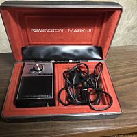 Remington Mark III electric shaver inside a red-lined case with a power cord included.