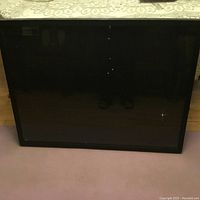 Front view of shadow box display case showing black frame and glass front.