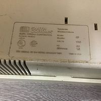 Close-up of Smith Corona metal label showing model XE5200 and electrical specifications.