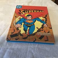 Front cover of Superman book showing Superman breaking through a brick wall with title text