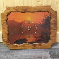 Front view of Aristocratic wooden framed wall clock with scenic sunset background, Roman numerals on face.